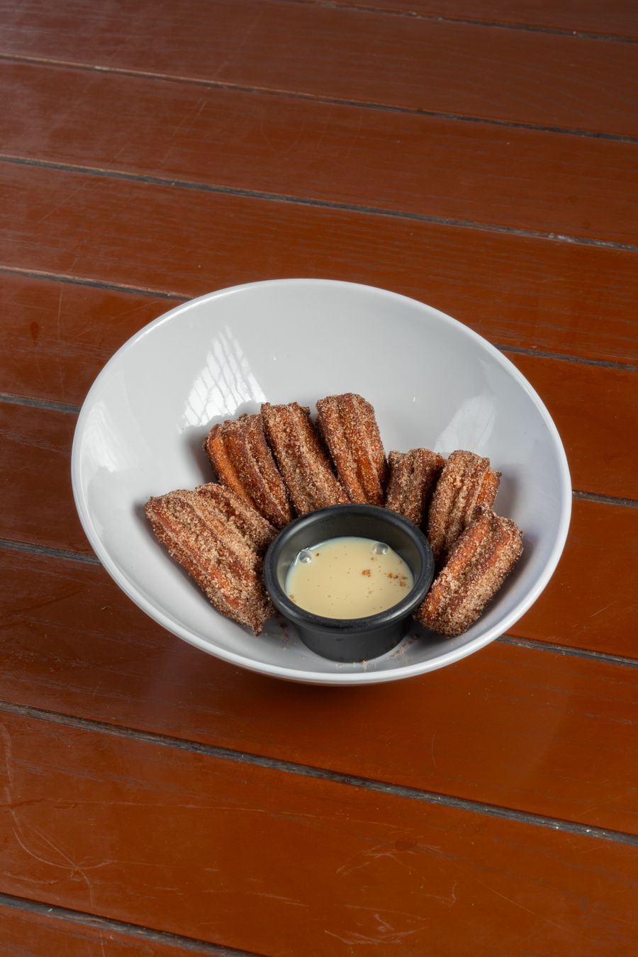Bowl of churros with warm dipping sauce