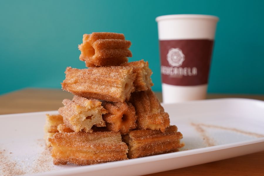 Stack of cinnamon sugar churros with coffee