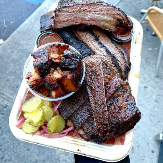 A Herc's Barbecue platter — sliced brisket, burnt ends, sausage, pickles and onions.