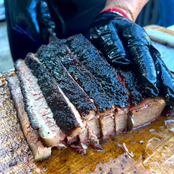 Freshly sliced oak-smoked brisket with a deep bark.