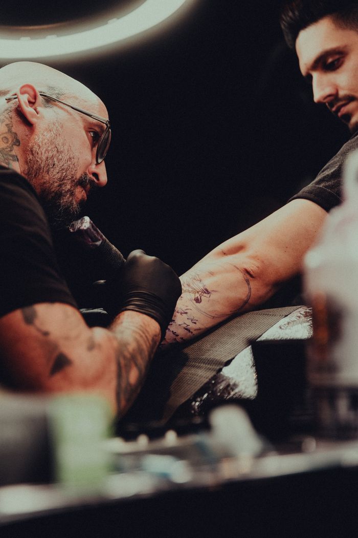 Artist creating an intricate arm design