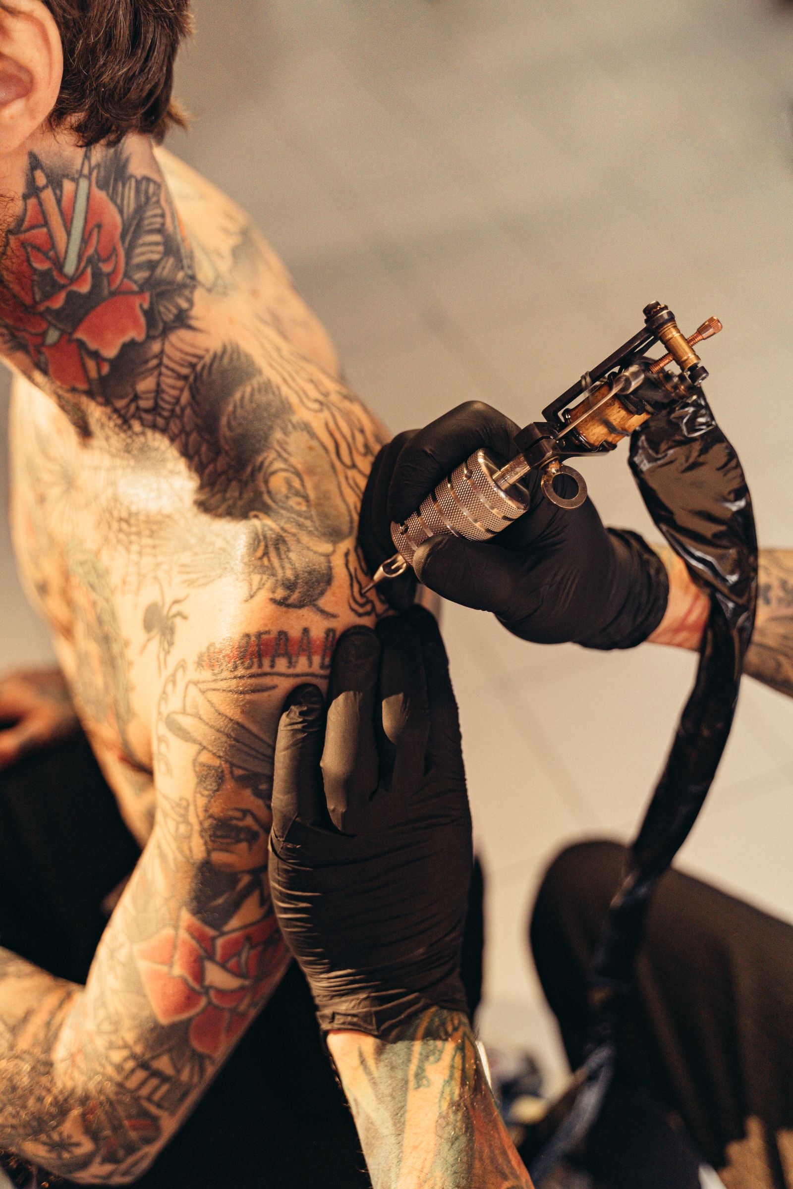 Tattoo artist working on a client's arm in the studio