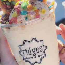 A Fruity Pebbles churro sundae topped with cereal in a Ridges cup.